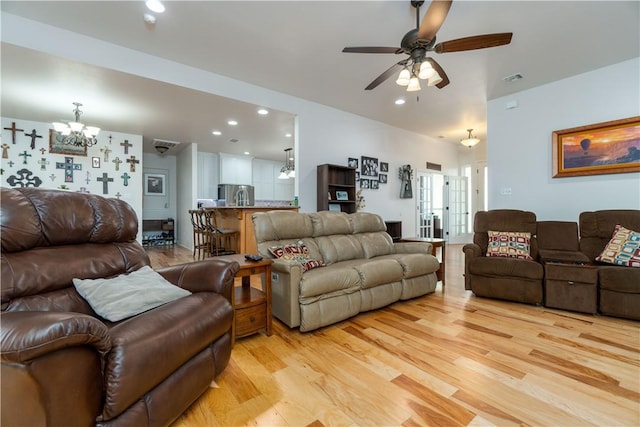 living room with ceiling fan with notable chandelier, light wood finished floors, visible vents, and recessed lighting