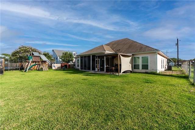 back of house featuring a yard, a playground, and a fenced backyard