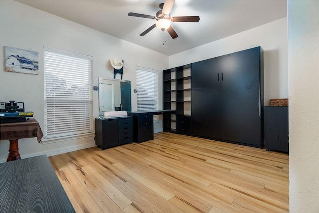 office area featuring a ceiling fan, light wood-type flooring, and baseboards