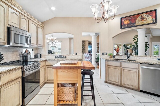 122 Bay Ct, Aransas Pass, TX 78336 - kitchen with stainless steel appliances, light brown cabinets, a sink, a chandelier, and vaulted ceiling