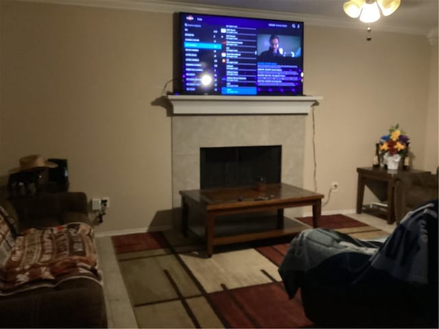 living room with ceiling fan, wood-type flooring, and ornamental molding