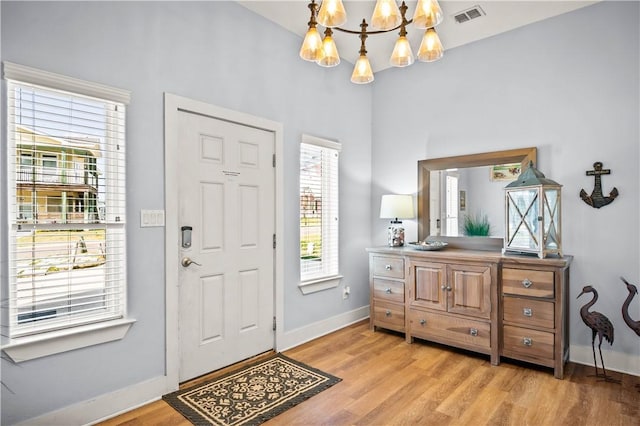 678 Anchor Dr, Port Aransas, TX 78373 - foyer entrance featuring a chandelier, light wood-style floors, baseboards, and a high ceiling