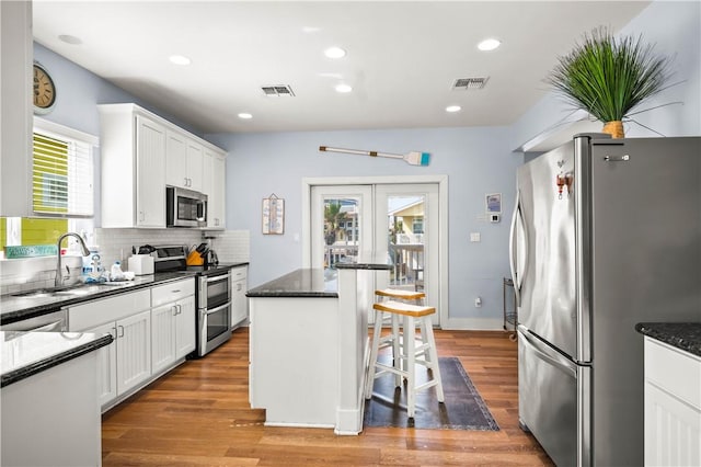 678 Anchor Dr, Port Aransas, TX 78373 - kitchen featuring appliances with stainless steel finishes, french doors, a kitchen breakfast bar, a sink, and white cabinets