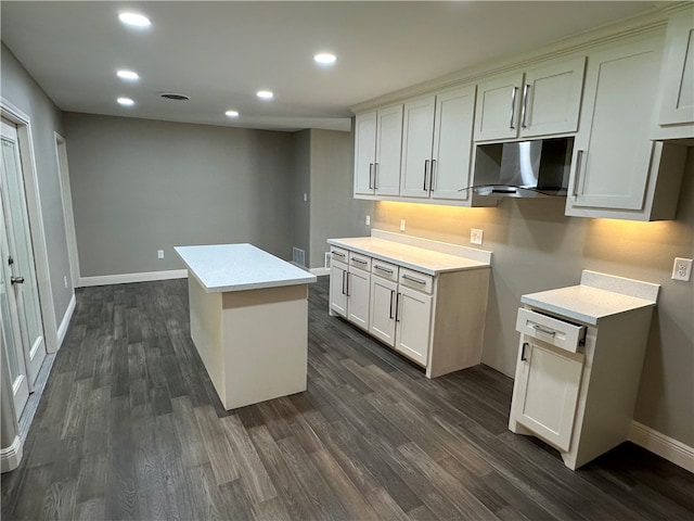 kitchen with white cabinets, ventilation hood, dark hardwood / wood-style flooring, and a center island