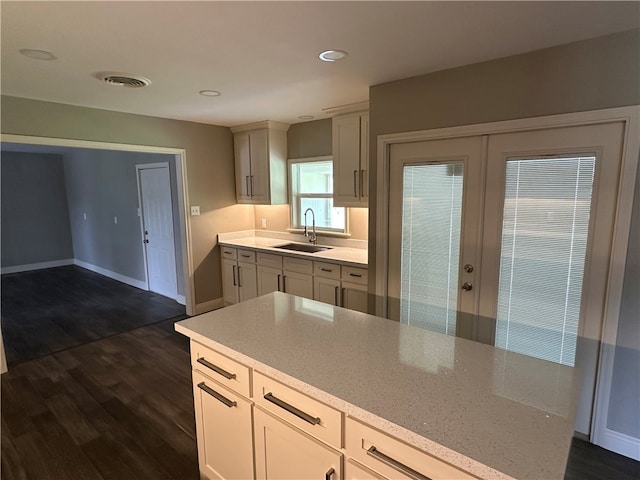 kitchen with dark hardwood / wood-style floors, white cabinetry, sink, and french doors