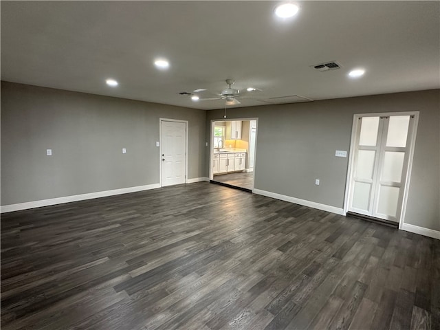 empty room with dark wood-type flooring, ceiling fan, and sink