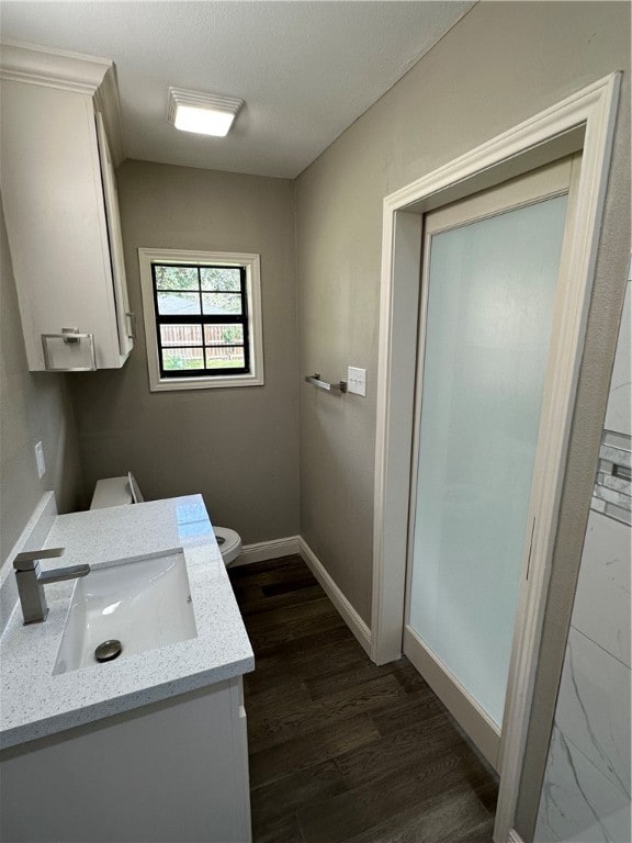 bathroom featuring wood-type flooring, toilet, and vanity