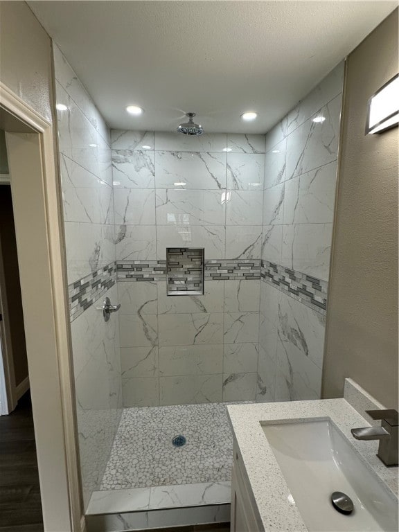 bathroom featuring vanity, hardwood / wood-style flooring, and a tile shower