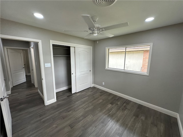 unfurnished bedroom with dark wood-type flooring, ceiling fan, and a closet