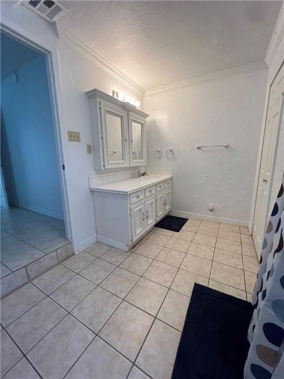 bathroom with tile patterned floors, visible vents, a textured ceiling, crown molding, and vanity