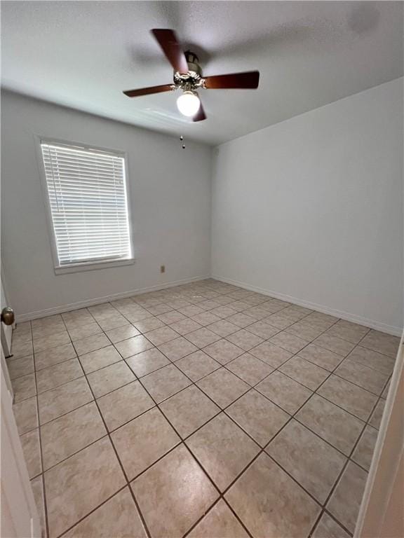 unfurnished room with baseboards and a ceiling fan