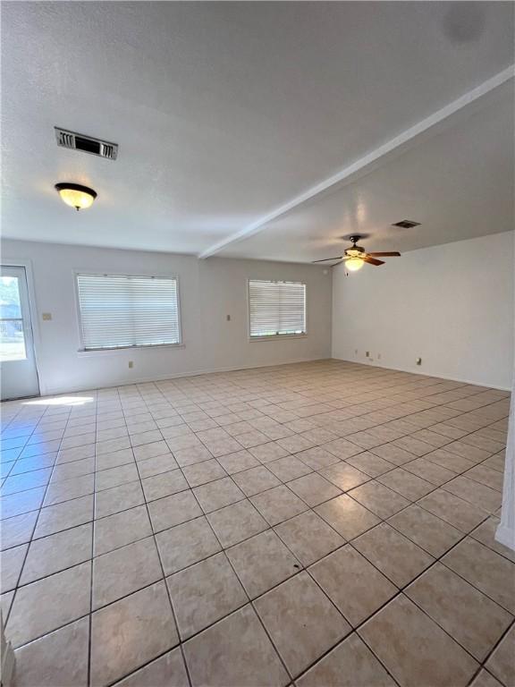 empty room featuring light tile patterned floors, visible vents, and ceiling fan