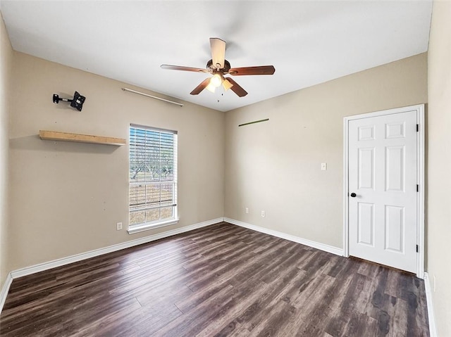 empty room with ceiling fan and dark wood-type flooring