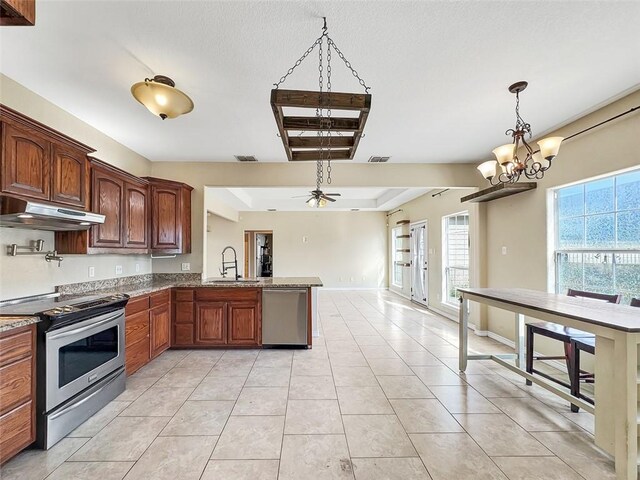 kitchen featuring ceiling fan with notable chandelier, sink, hanging light fixtures, kitchen peninsula, and stainless steel appliances