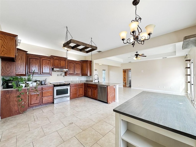 kitchen with kitchen peninsula, appliances with stainless steel finishes, ceiling fan with notable chandelier, and pendant lighting