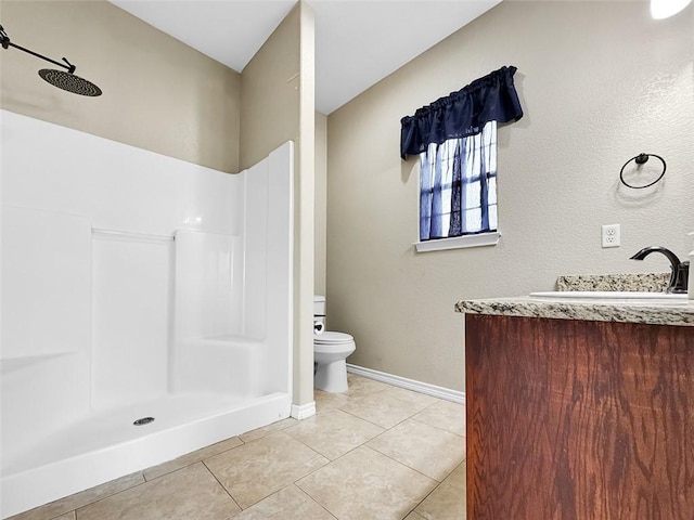 bathroom with a shower, tile patterned floors, vanity, and toilet