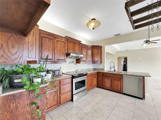 kitchen featuring light stone countertops, ceiling fan, sink, stainless steel appliances, and kitchen peninsula