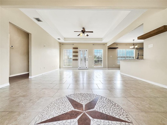 living room with a tray ceiling, light tile patterned flooring, and ceiling fan with notable chandelier