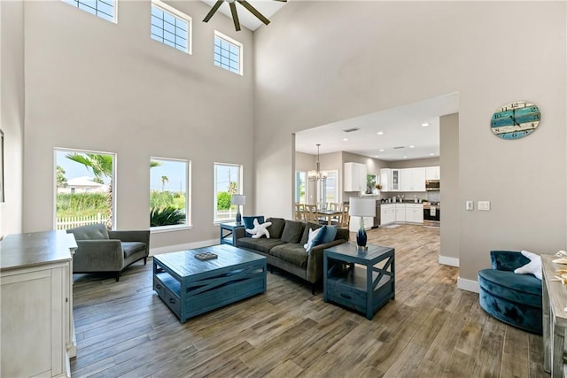 110 Keewaydin Ln, Port Aransas, TX 78373 - living room with a towering ceiling, ceiling fan, wood finished floors, and a chandelier