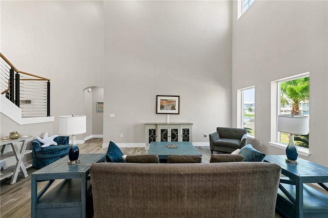 110 Keewaydin Ln, Port Aransas, TX 78373 - living room featuring a high ceiling, arched walkways, wood finished floors, and healthy amount of natural light