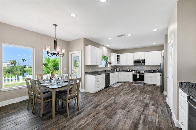 110 Keewaydin Ln, Port Aransas, TX 78373 - dining area featuring plenty of natural light, dark wood finished floors, a chandelier, and recessed lighting