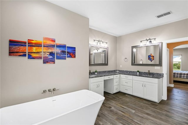 110 Keewaydin Ln, Port Aransas, TX 78373 - full bath with double vanity, a freestanding tub, and wood finished floors
