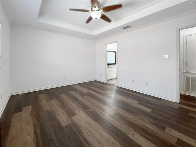 spare room featuring ornamental molding, dark hardwood / wood-style floors, ceiling fan, and a tray ceiling