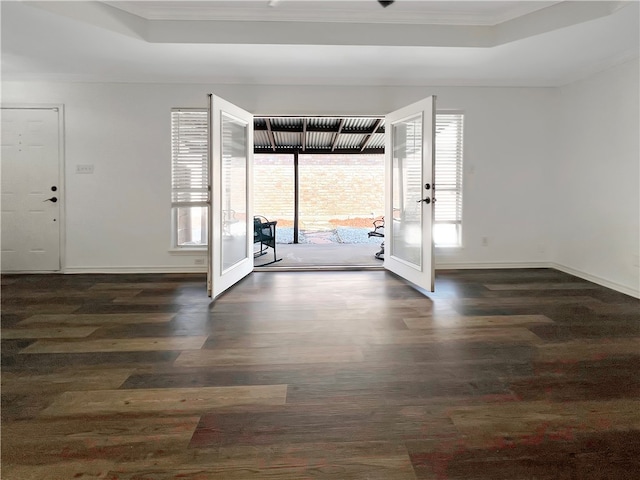 foyer featuring dark hardwood / wood-style flooring, french doors, ornamental molding, and a raised ceiling