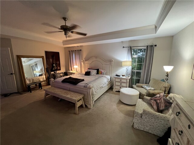 bedroom featuring ornamental molding, light carpet, ceiling fan, and a raised ceiling