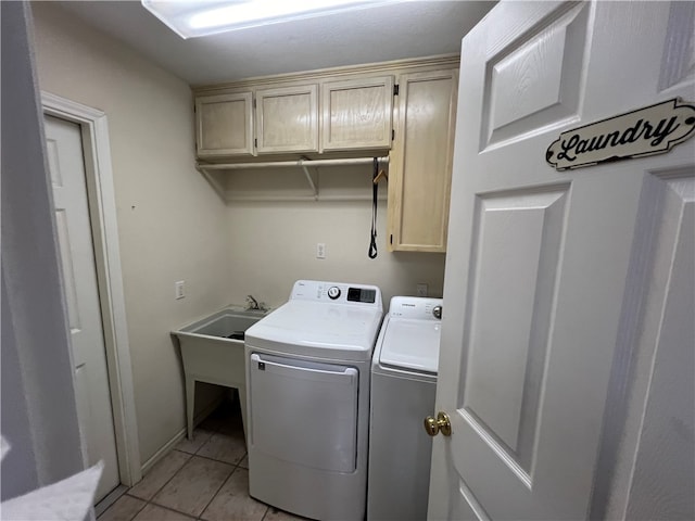 washroom featuring cabinets, light tile patterned floors, and washing machine and clothes dryer