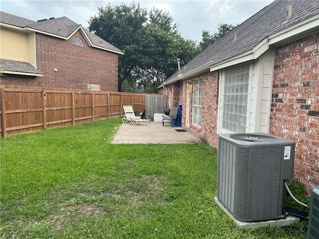 view of yard with central AC and a patio