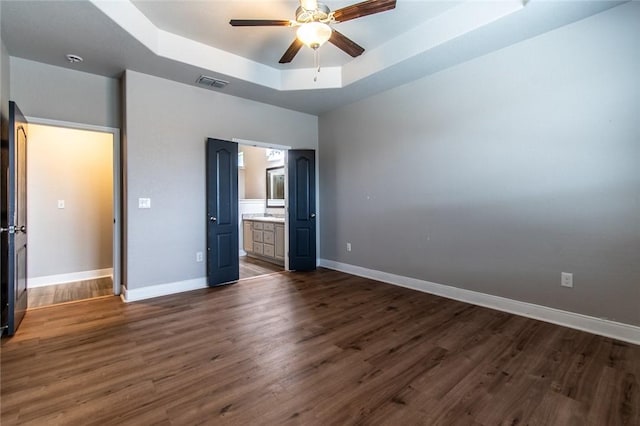 8022 Calgary Dr, Corpus Christi, TX 78414 - unfurnished bedroom featuring a tray ceiling, dark wood finished floors, ensuite bathroom, and a ceiling fan