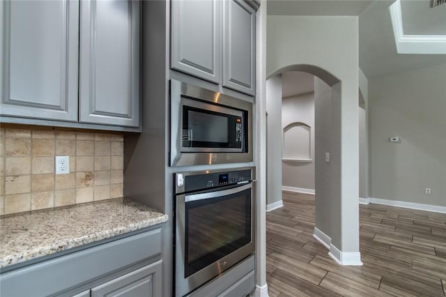 8022 Calgary Dr, Corpus Christi, TX 78414 - kitchen with stainless steel appliances, gray cabinets, arched walkways, and backsplash