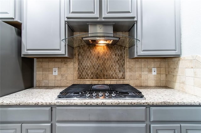 8022 Calgary Dr, Corpus Christi, TX 78414 - kitchen with stainless steel gas stovetop, backsplash, extractor fan, and gray cabinetry