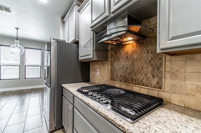8022 Calgary Dr, Corpus Christi, TX 78414 - kitchen featuring stainless steel gas cooktop, range hood, decorative backsplash, and gray cabinets