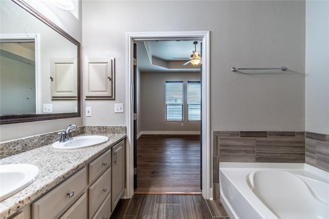 8022 Calgary Dr, Corpus Christi, TX 78414 - bathroom featuring double vanity, a bath, ceiling fan, and wood finished floors