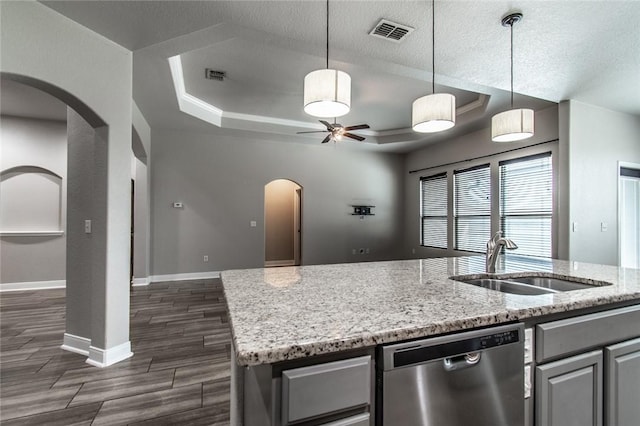 8022 Calgary Dr, Corpus Christi, TX 78414 - kitchen with stainless steel dishwasher, arched walkways, a ceiling fan, a center island with sink, and dark wood-style floors