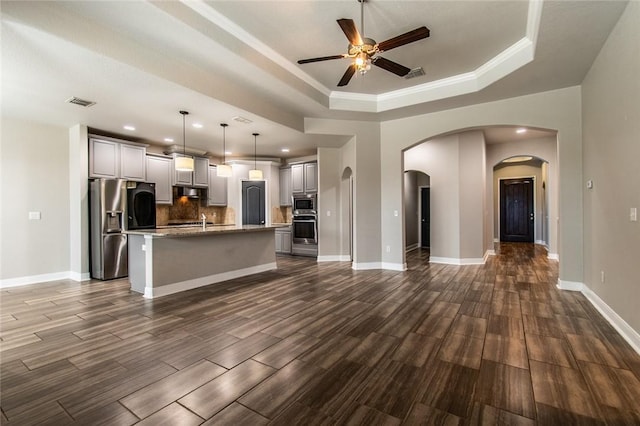 8022 Calgary Dr, Corpus Christi, TX 78414 - kitchen with appliances with stainless steel finishes, a tray ceiling, a ceiling fan, arched walkways, and open floor plan