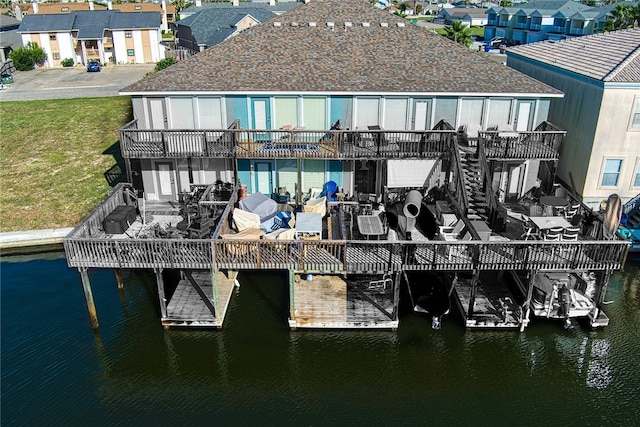 exterior space featuring a lawn and a deck with water view