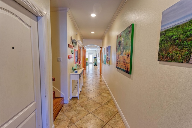 corridor with light tile patterned flooring and ornamental molding