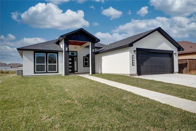 view of front of home with central AC unit, a front yard, and a garage