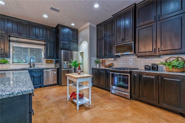 4609 Tuscan Way, Corpus Christi, TX 78410 - kitchen with appliances with stainless steel finishes, finished concrete flooring, recessed lighting, backsplash, and crown molding