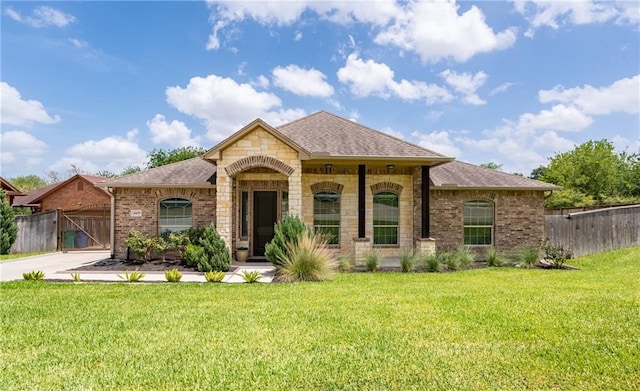 4609 Tuscan Way, Corpus Christi, TX 78410 - french country home featuring a shingled roof, brick siding, stone siding, and concrete driveway