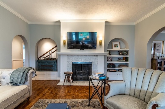 261 Louisiana Ave, Corpus Christi, TX 78404 - living area featuring arched walkways, crown molding, a fireplace with flush hearth, a textured ceiling, and built in shelves