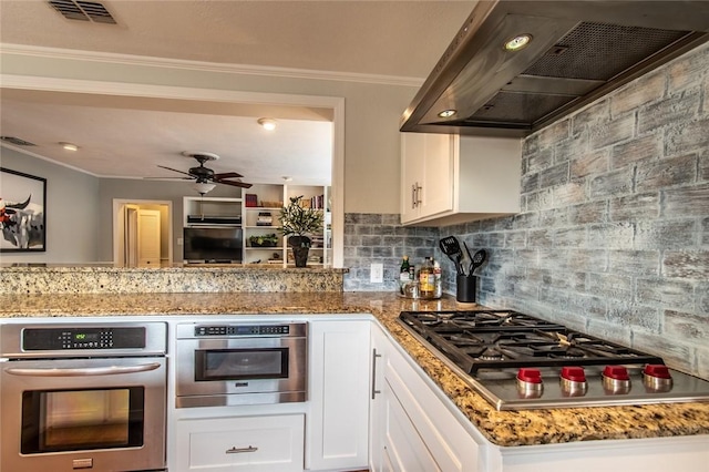 261 Louisiana Ave, Corpus Christi, TX 78404 - kitchen with wall chimney range hood, appliances with stainless steel finishes, ornamental molding, tasteful backsplash, and white cabinetry