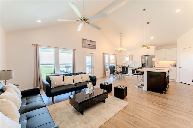living room with light wood-style floors, high vaulted ceiling, plenty of natural light, ceiling fan, and recessed lighting