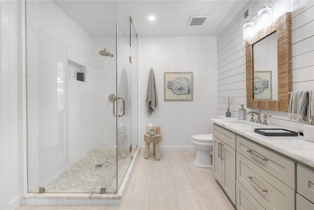 full bath featuring vanity, toilet, visible vents, and a stall shower