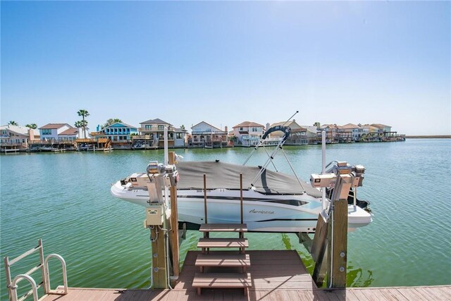 view of dock featuring a residential view, a water view, and boat lift