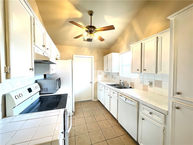 kitchen with white cabinetry, light tile patterned floors, tile counters, white appliances, and lofted ceiling