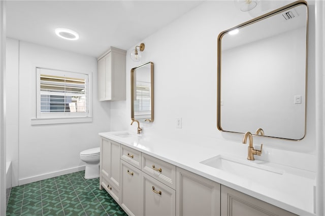 bathroom featuring vanity, a tub, tile patterned floors, and toilet